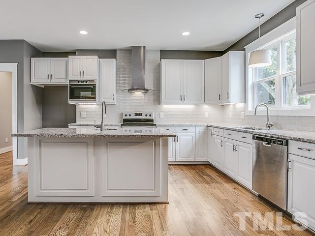 1002 Caspan Street Raleigh, NC 27610 - Photo 7 of 25 a kitchen with stainless steel appliances granite countertop a sink a stove a refrigerator cabinets and a counter top space