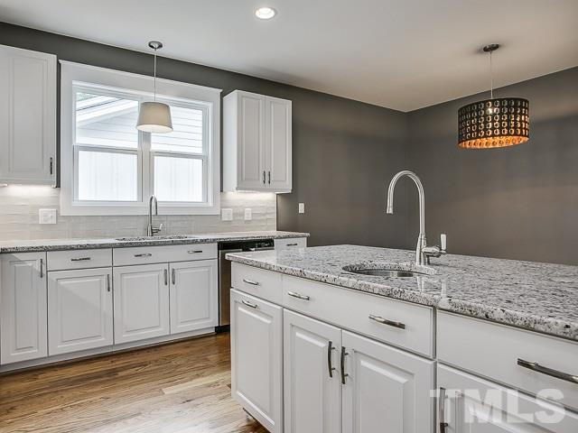 1002 Caspan Street Raleigh, NC 27610 - Photo 9 of 25 a kitchen with granite countertop stainless steel appliances sink cabinets and window
