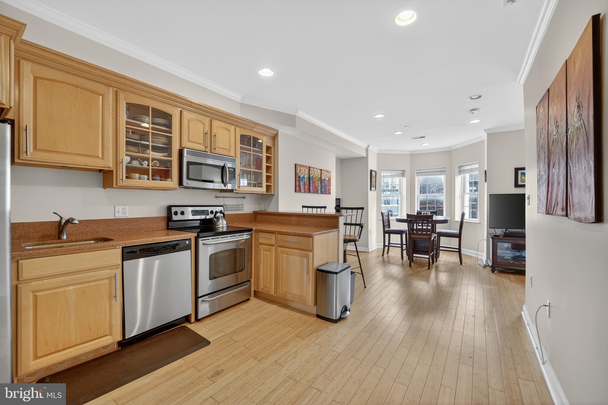 1337 Harvard Street Northwest, Unit 2 Washington, DC 20009 - Photo 3 of 23 a kitchen with a table chairs stove and cabinets