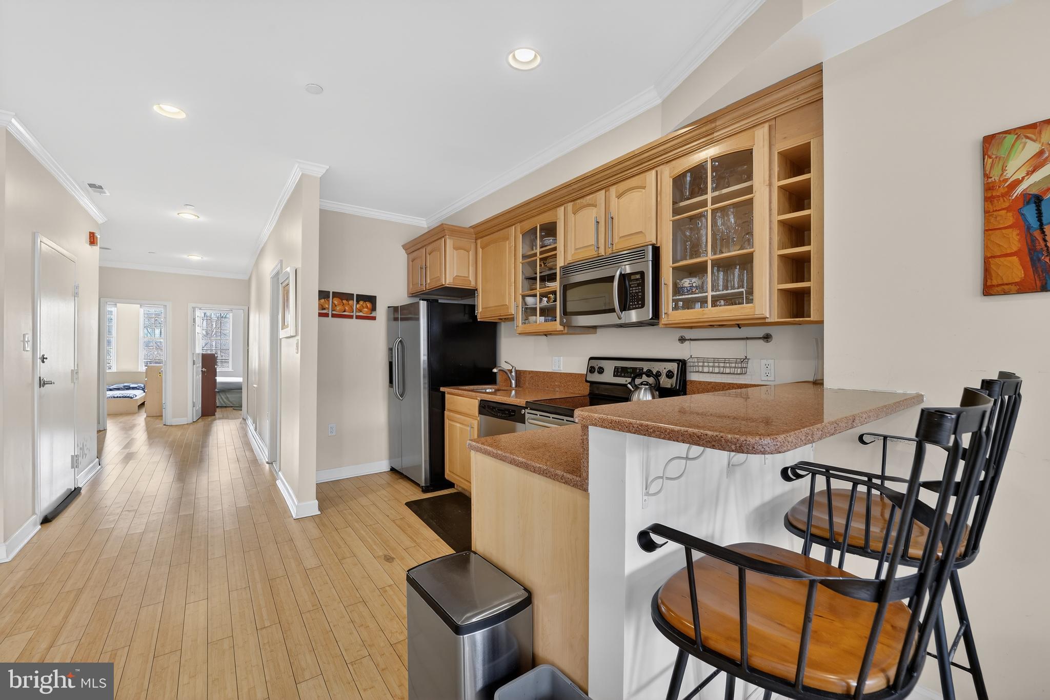 1337 Harvard Street Northwest, Unit 2 Washington, DC 20009 - Photo 8 of 23 a kitchen with stainless steel appliances granite countertop a refrigerator a stove top oven a sink dishwasher and white cabinets with wooden floor