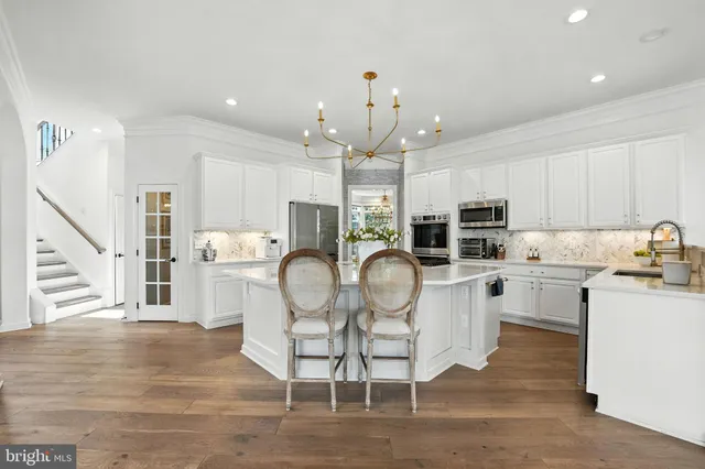 a view of a dining room and livingroom with furniture wooden floor a chandelier
