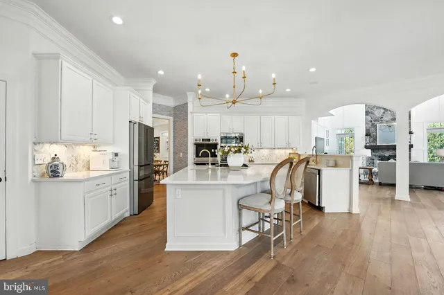 a dining room with wooden floor a chandelier a wooden table and chairs