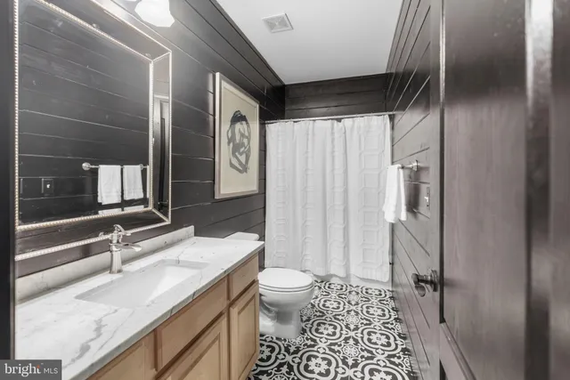 a view of a brick house with a big yard and potted plants