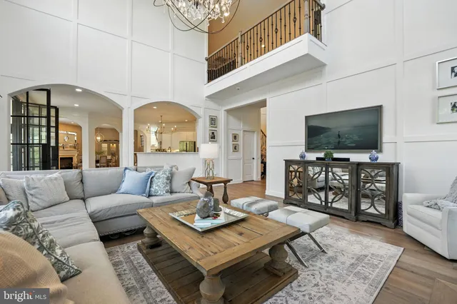 a living room with furniture large window and wooden floor