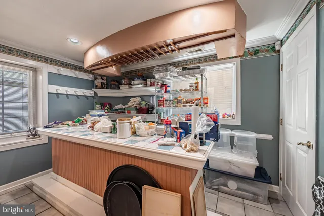 a room with stainless steel appliances kitchen island a large window in it