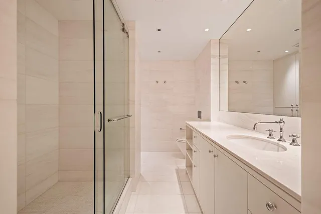 a bathroom with a sink a toilet and shower