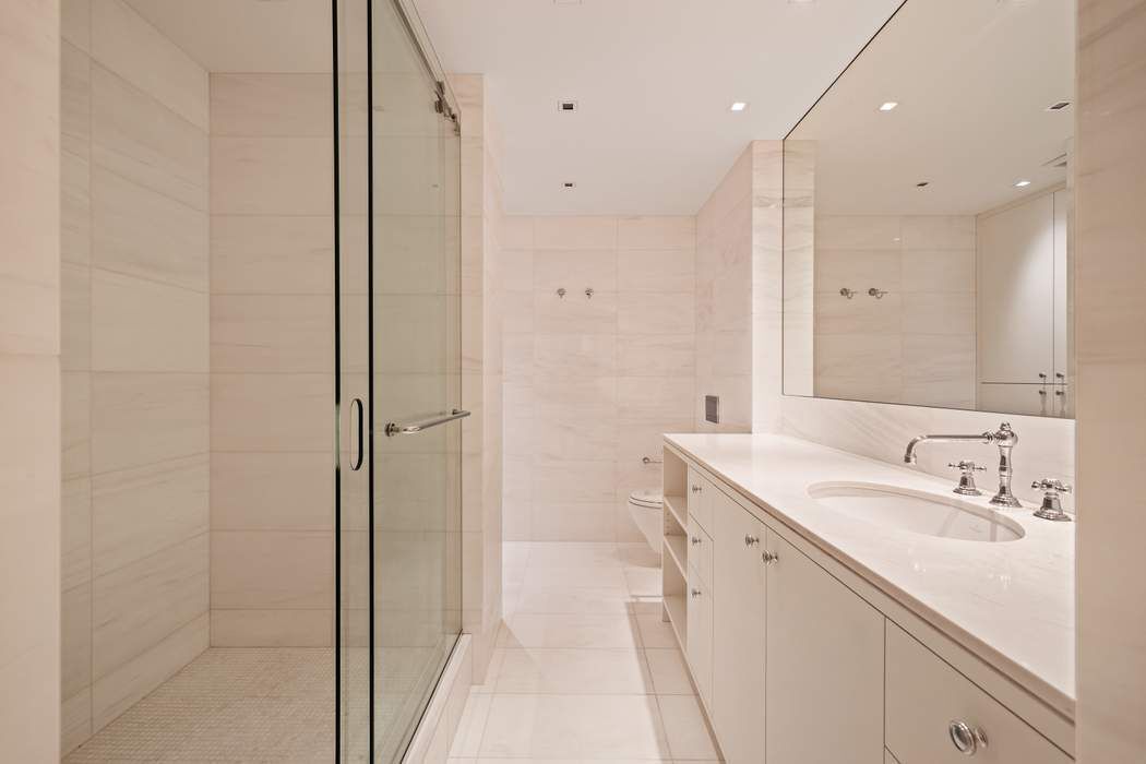 425 East 58th Street, Unit 20E Manhattan, NY 10022 - Photo 12 of 19 a bathroom with a sink a toilet and shower