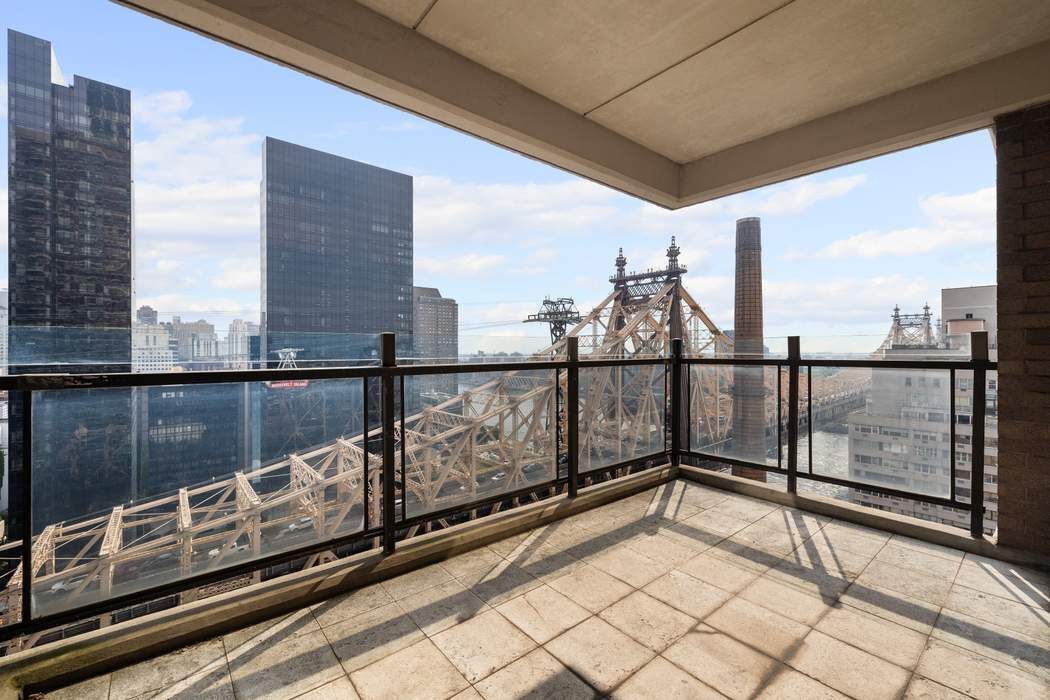 425 East 58th Street, Unit 20E Manhattan, NY 10022 - Photo 4 of 19 a view of a balcony with wooden floor and iron stairs