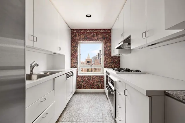 a kitchen with stainless steel appliances a sink stove and cabinets