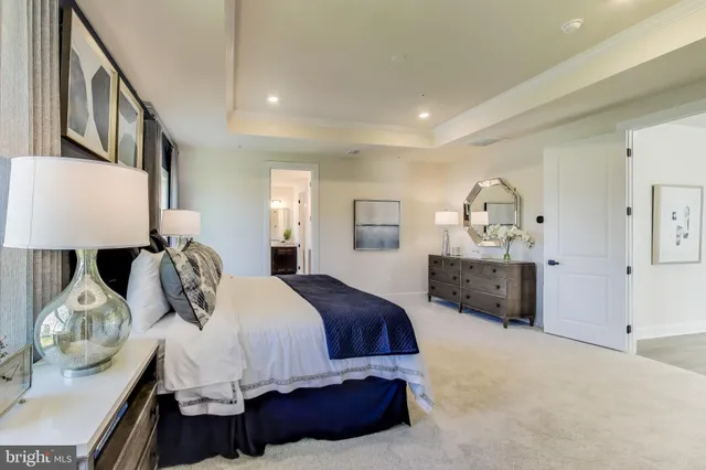 a spacious bedroom with a bed a window and dresser