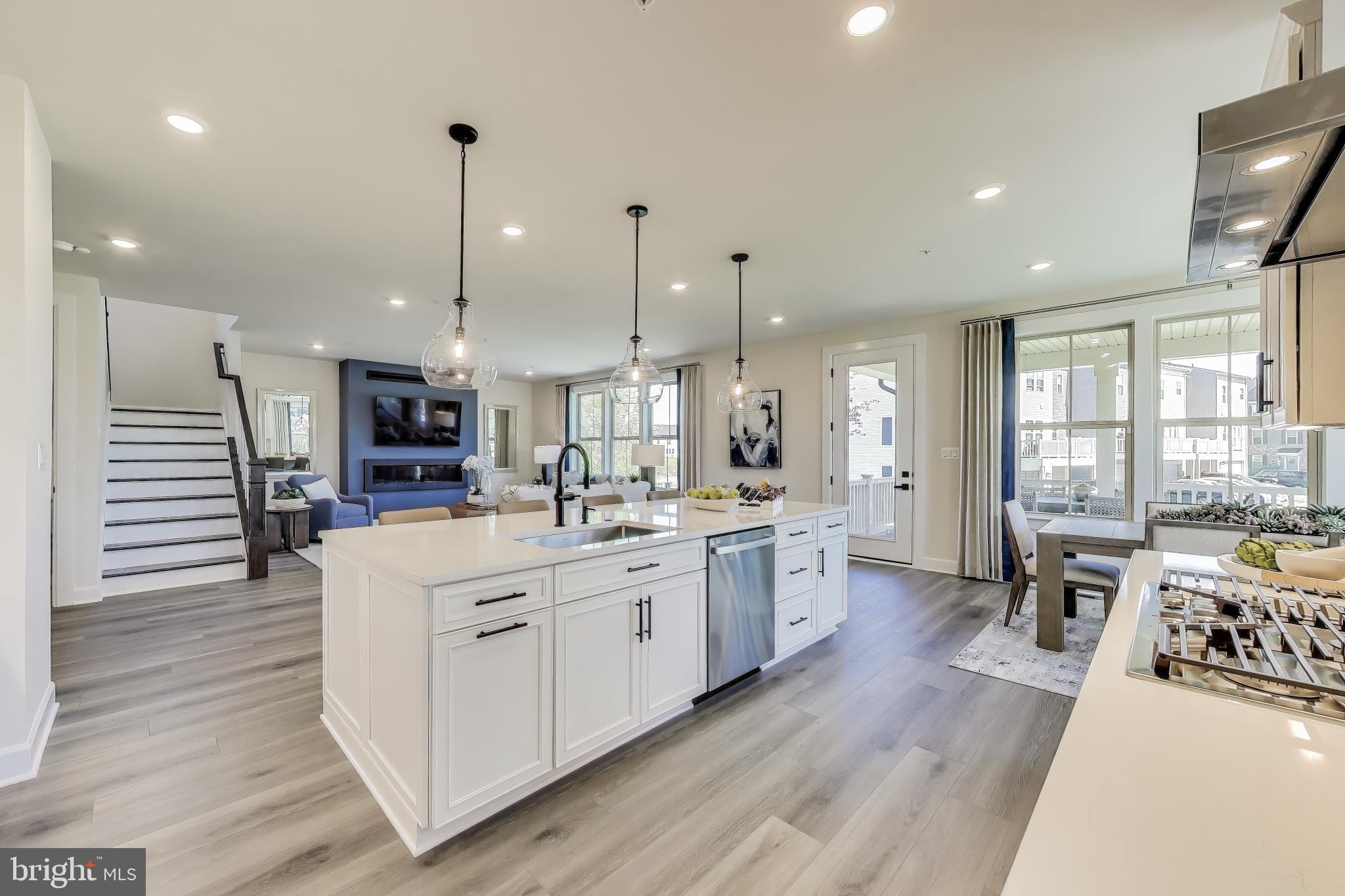 1303 Clubhouse Boulevard Laurel, MD 20708 - Photo 9 of 18 a large kitchen with kitchen island a large island a sink a stove and wooden floor
