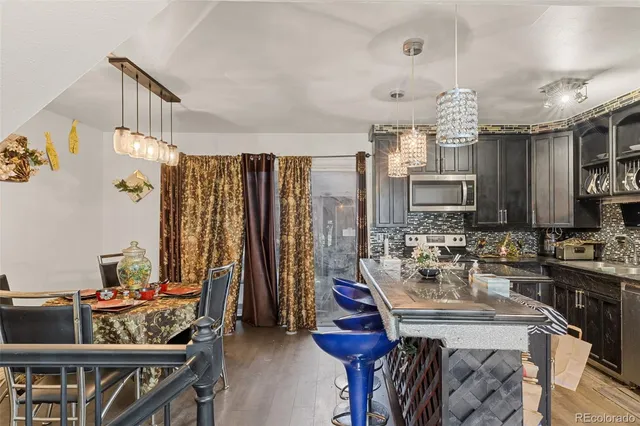 a kitchen with sink refrigerator dining table and chairs