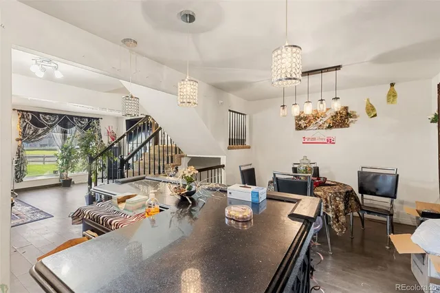 a view of a dining room with furniture a chandelier and large windows