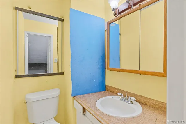 a bathroom with a sink a toilet and mirror