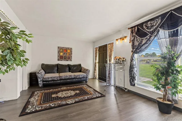 a living room with furniture and a potted plant