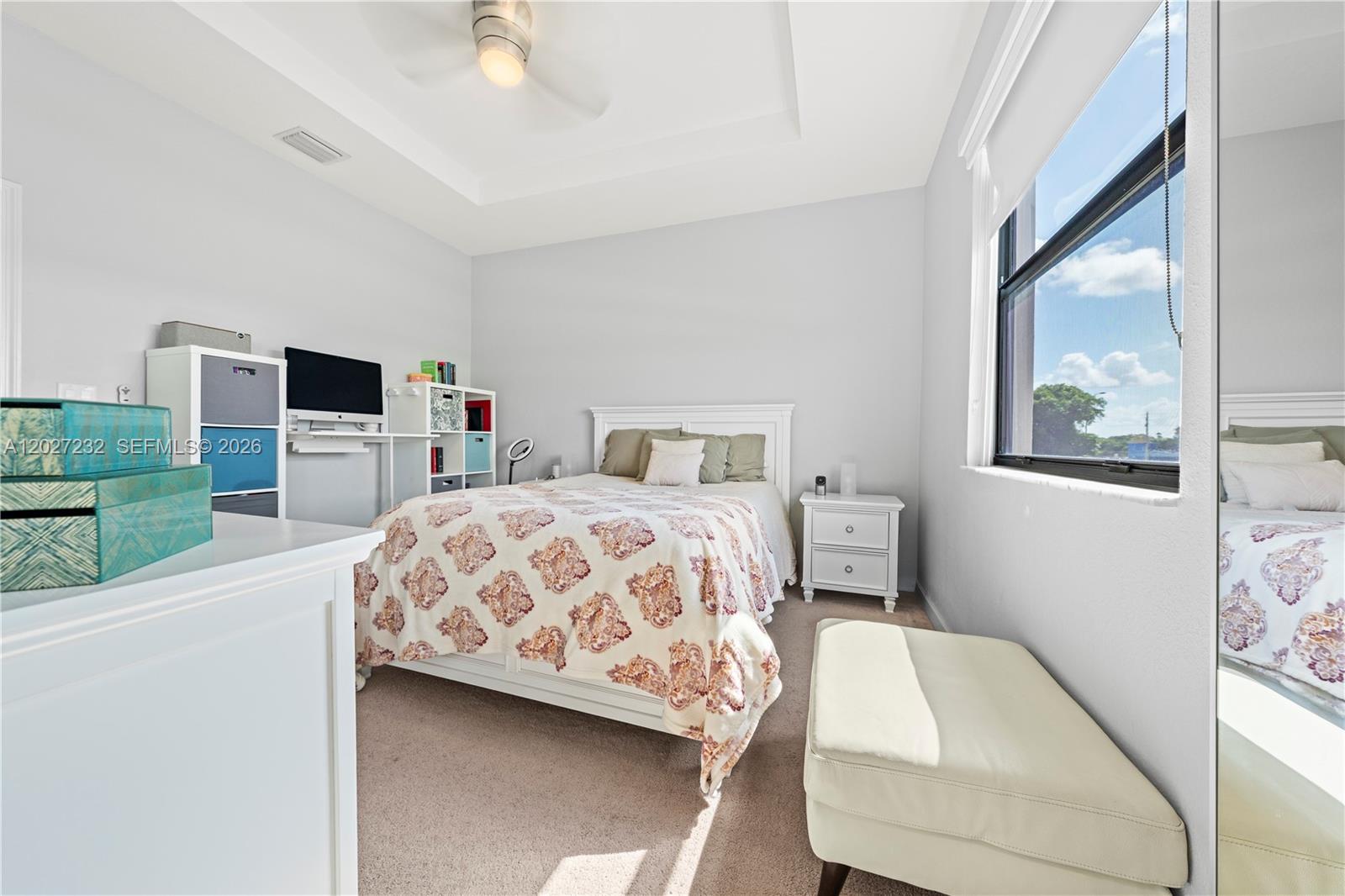 23489 Southwest 127th Place Homestead, FL 33032 - Photo 13 of 24 a bedroom with a large bed and a chandelier
