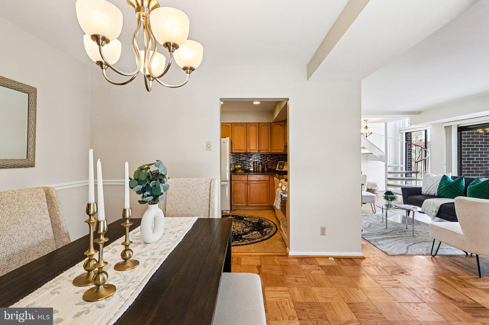 9900 Georgia Avenue, Unit 27217 Silver Spring, MD 20902 - Photo 14 of 50 a living room with furniture a chandelier and a dining table