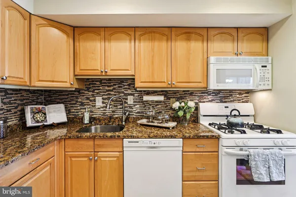 a kitchen with stainless steel appliances granite countertop a sink a stove and a microwave