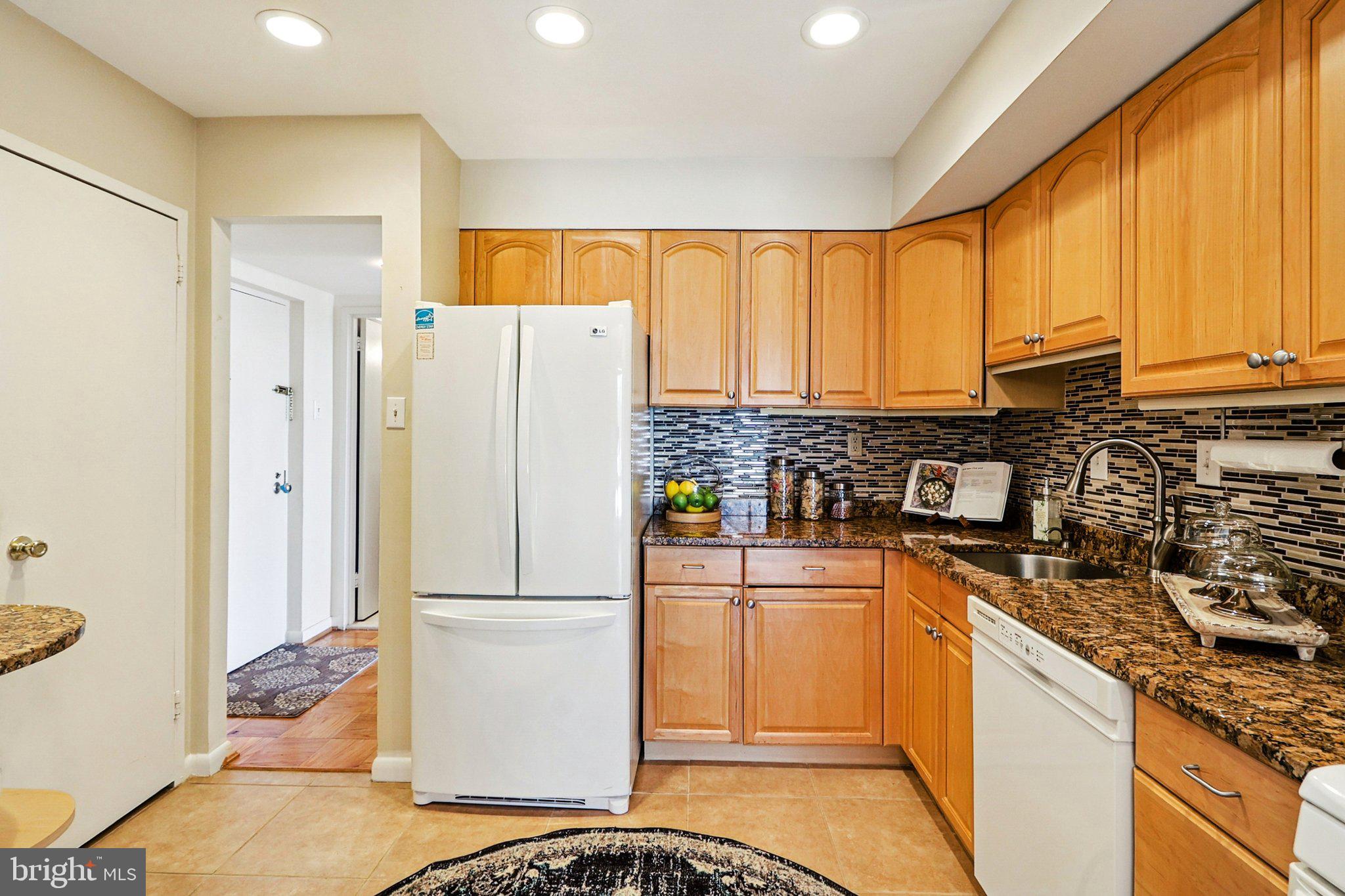9900 Georgia Avenue, Unit 27217 Silver Spring, MD 20902 - Photo 18 of 50 a kitchen with stainless steel appliances granite countertop a refrigerator sink and cabinets