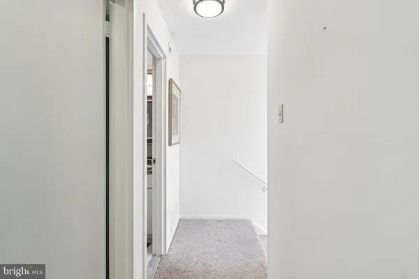 a bedroom with a bed and a lamp on dresser