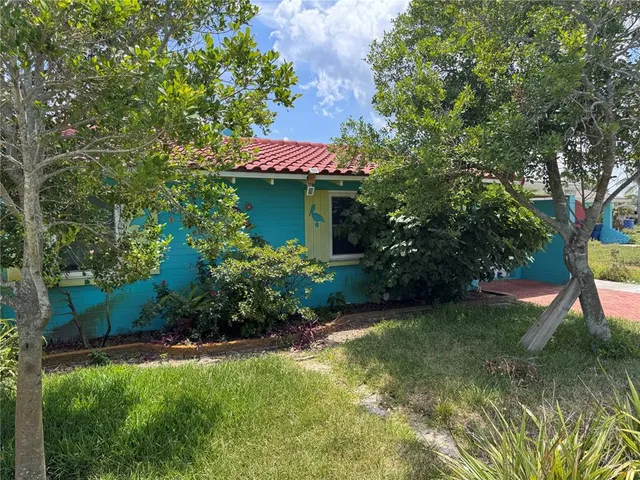 a view of a backyard with chairs and table under an umbrella