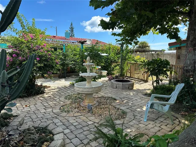 a view of a backyard with plants and a patio