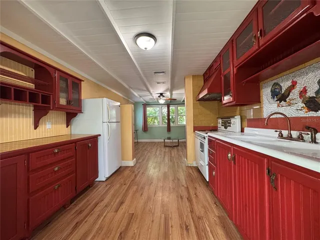 a kitchen with wooden floors wooden cabinets and entryway