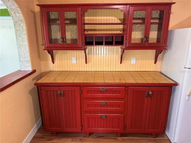 a kitchen with a refrigerator a stove and wooden floor