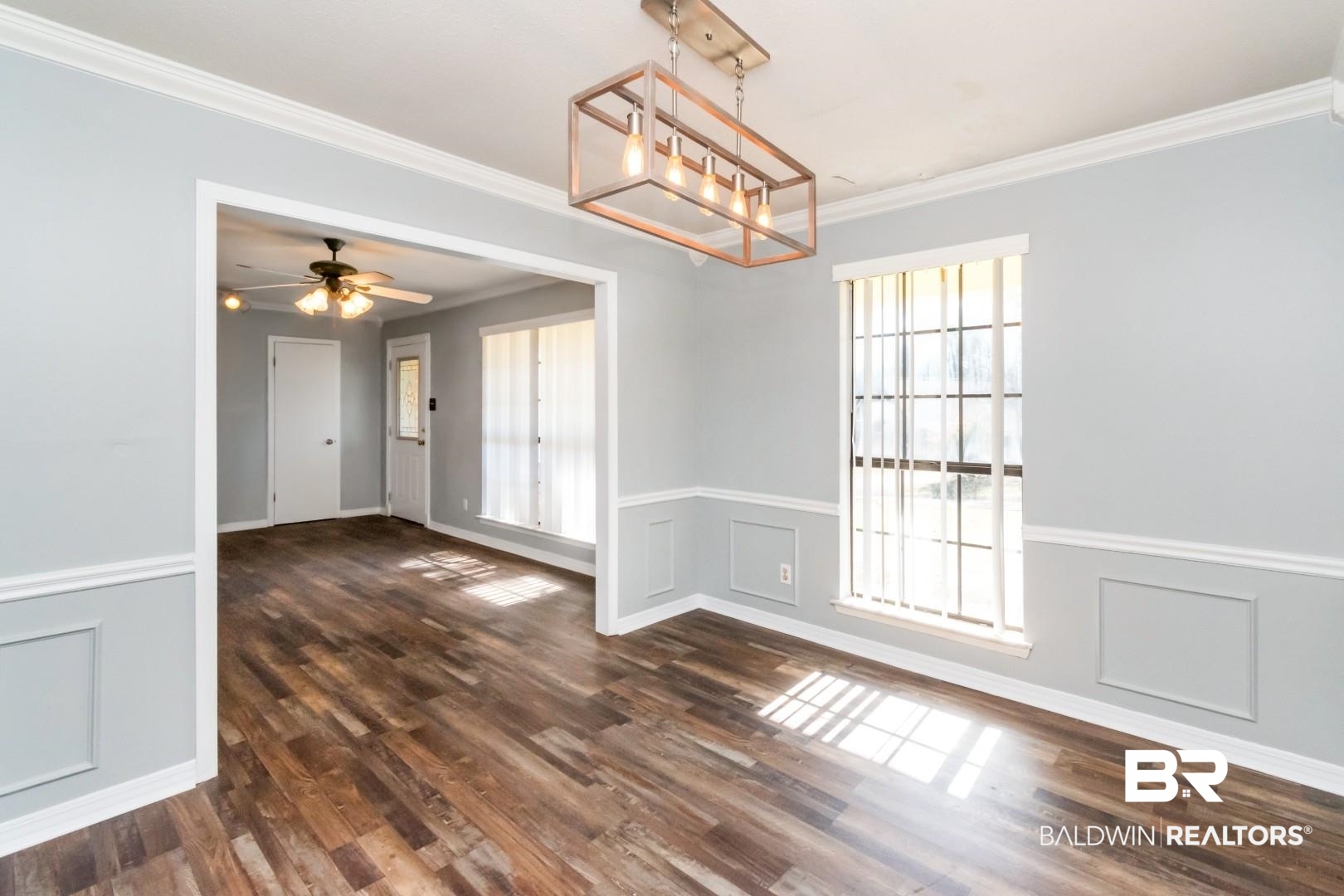 8304 Champlain Circle Mobile, AL 36695 - Photo 11 of 46 Unfurnished dining area featuring dark hardwood / wood-style flooring, ceiling fan with notable chandelier, a wealth of natural light, and ornamental molding