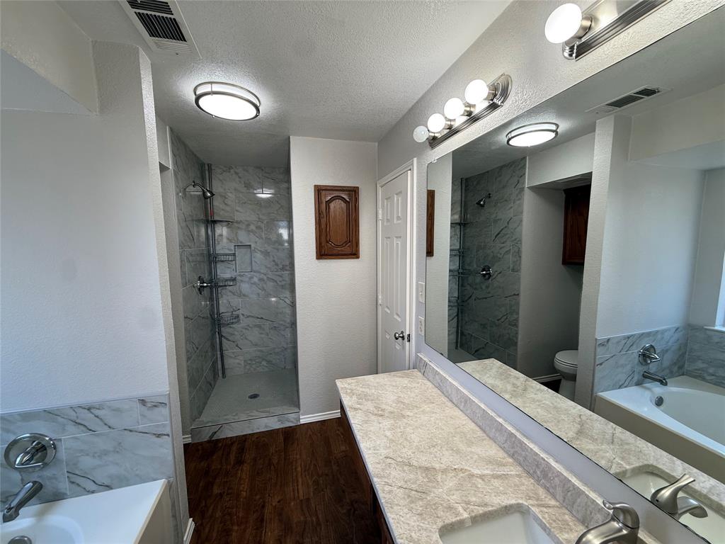 7913 Rice Drive Rowlett, TX 75088 - Photo 13 of 20 a bedroom with a bed and a chandelier