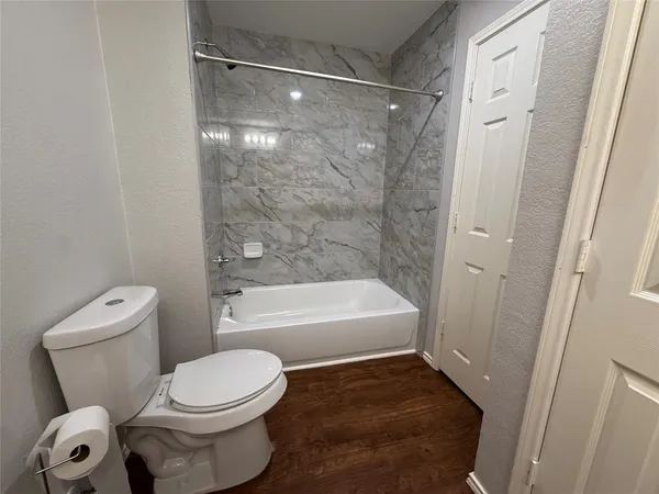 a bathroom with a toilet and a bath tub