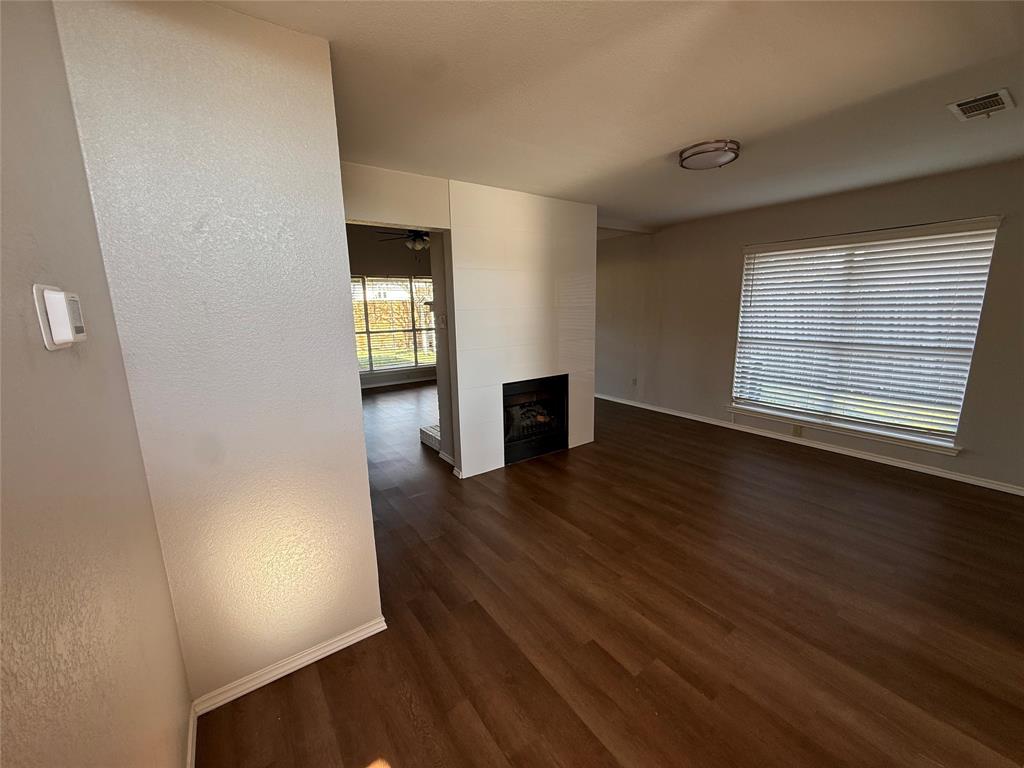 7913 Rice Drive Rowlett, TX 75088 - Photo 4 of 20 an empty room with wooden floor and windows