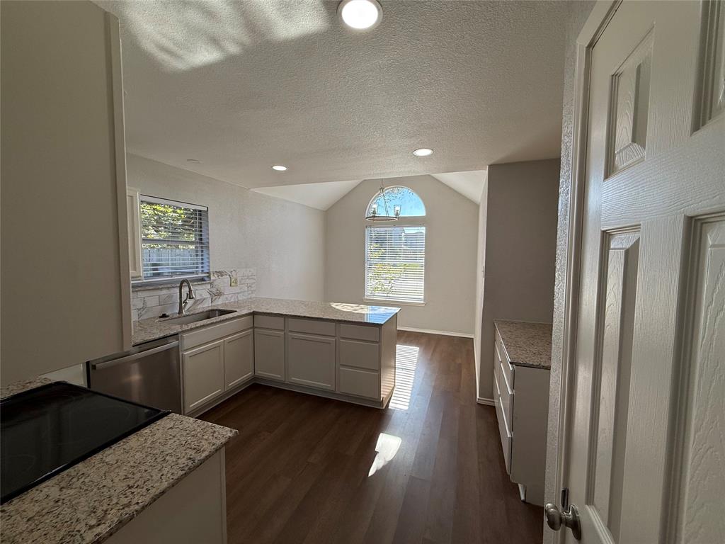 7913 Rice Drive Rowlett, TX 75088 - Photo 8 of 20 a kitchen with stainless steel appliances granite countertop a refrigerator a sink dishwasher a stove and white countertops with wooden floor