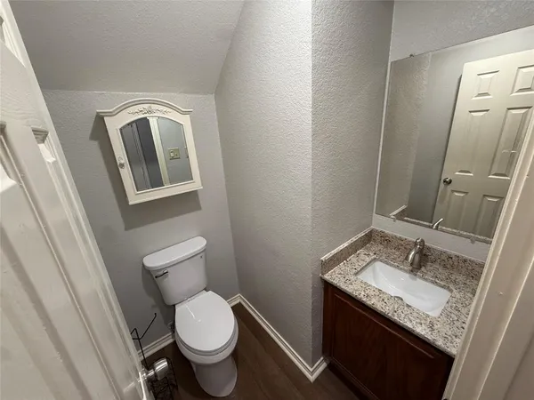 a bathroom with a granite countertop toilet sink and mirror