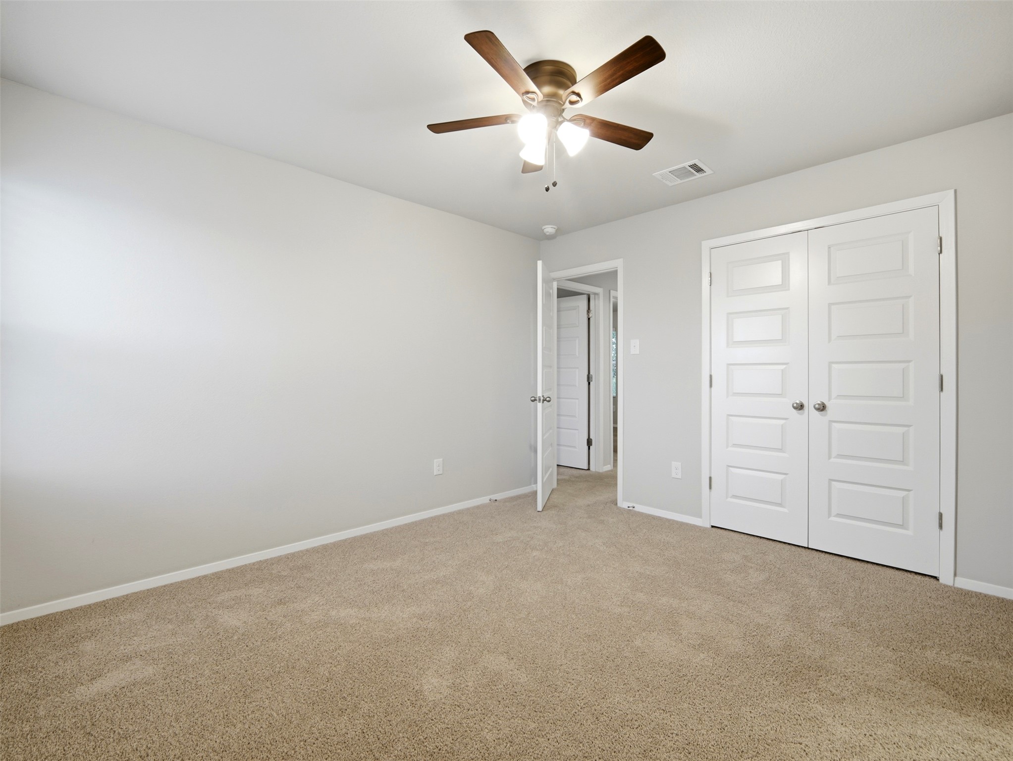 60 Bent Trl Lane Georgetown, TX 78628 - Photo 19 of 40 A well-lit bedroom features plush carpet flooring and convenient closet access.