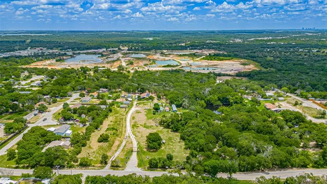 an aerial view of residential houses with outdoor space and trees