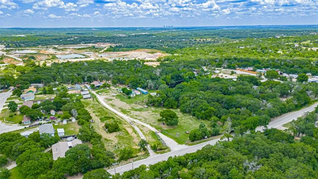an aerial view of residential houses with outdoor space and trees