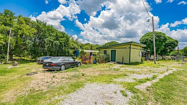 a view of a swimming pool with lawn chairs and plants