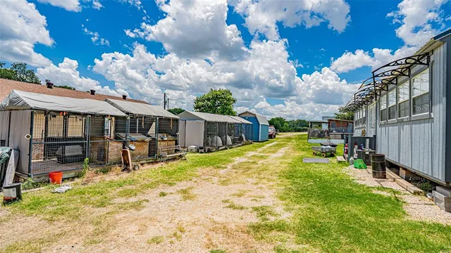 a view of a chair and table in backyard of the house