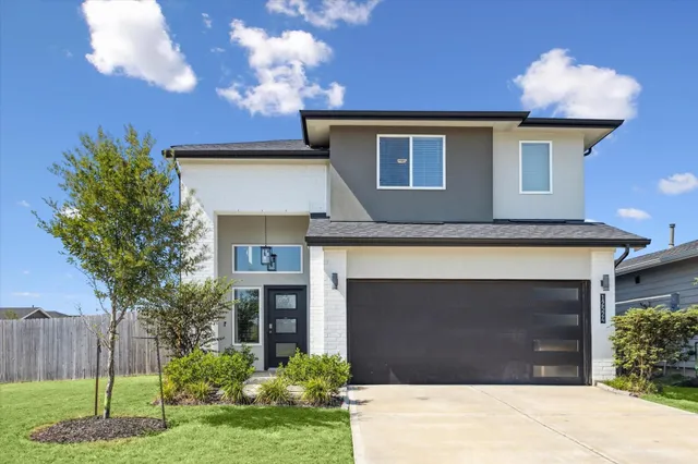 a front view of a house with a yard and garage