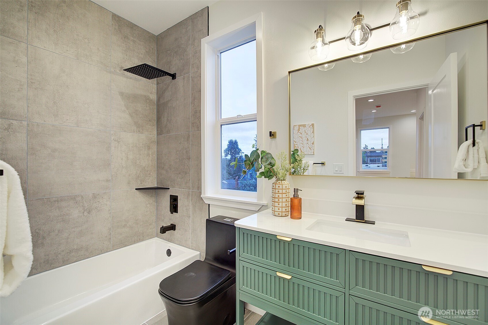 7008 Linden Avenue North Seattle, WA 98103 - Photo 21 of 39 a bathroom with a sink a toilet a mirror a bathtub and shower