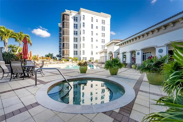 a front view of multi story residential apartment building with yard and parking