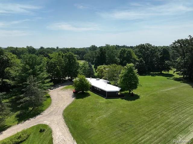 Extensive green space with mature trees and a gravel drive