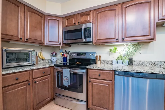 a kitchen with granite countertop stainless steel appliances microwave stove and sink