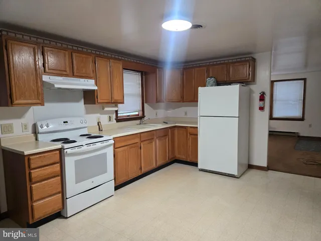 a kitchen with a stove a refrigerator and a sink