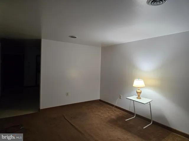 a room with a lamp wooden floor and a table