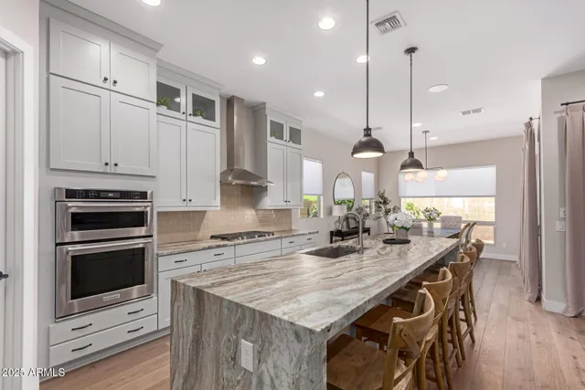 a kitchen with kitchen island a stove a center island a sink cabinets and wooden floor