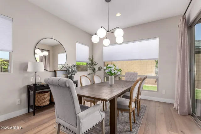a dining room with furniture a large window and wooden floor