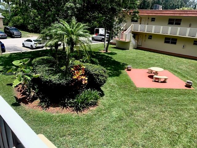 14901 Southwest 4th Street, Unit 9A Pembroke Pines, FL 33027 - Photo 2 of 6 a view of a house with a yard and potted plants