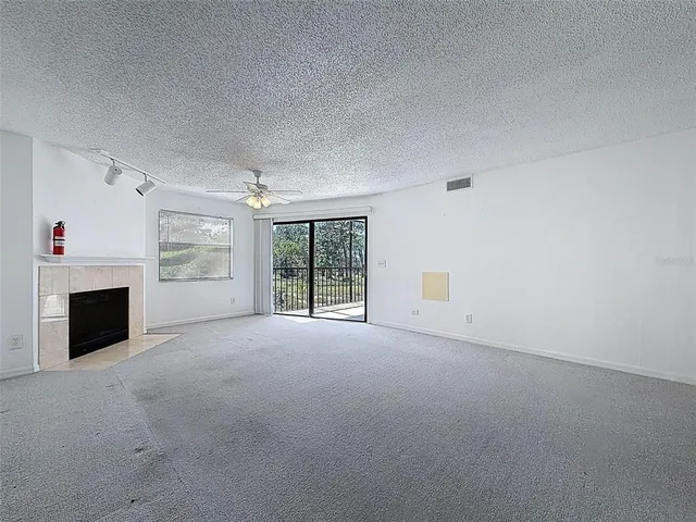 an empty room with a view of a ceiling fan and a window